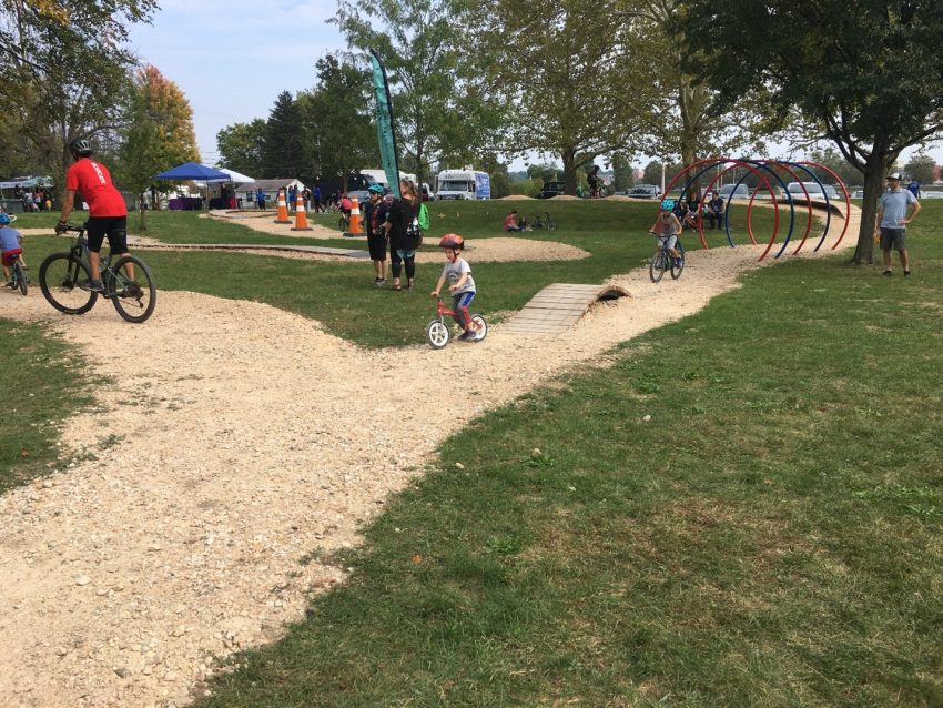 Children riding bikes on trail through bicycle playground at Dayton Bike Yard