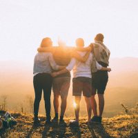 Group of Friends Atop Hill Embracing