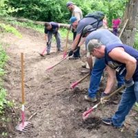 Volunteers Smoothing Trail in Wooded Area
